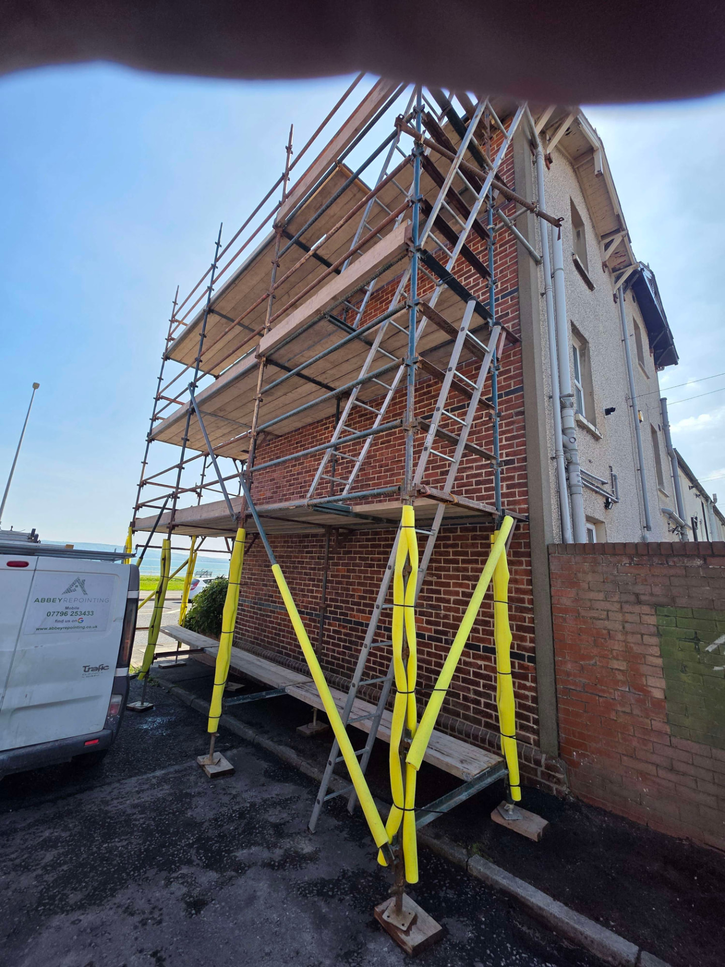 Scaffolded red brick gable end ready for repointing