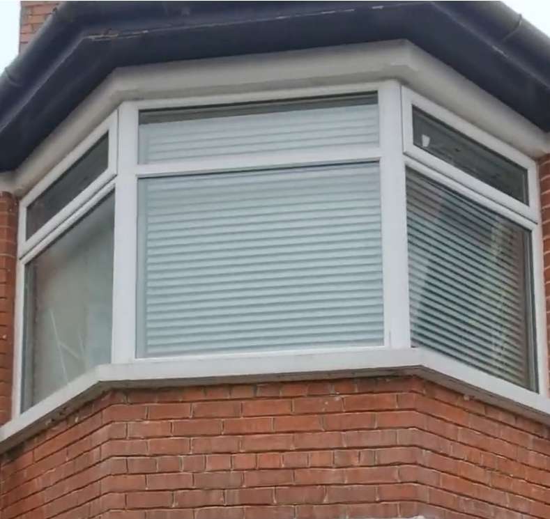 Bay window with white frame and red brickwork below