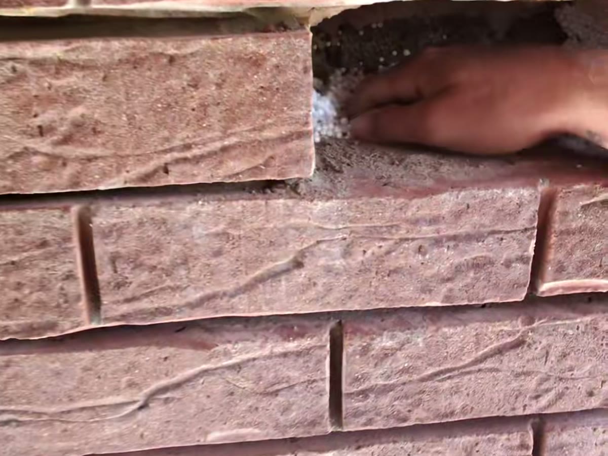 A replacement brick being bedded into a wall on a Northern Ireland home